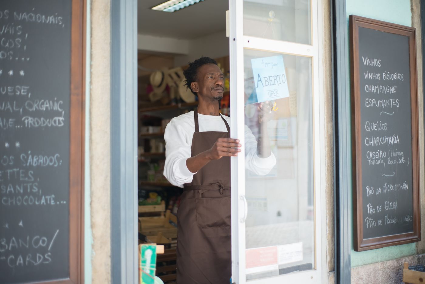 An independent shop owner opening up in the early morning light.